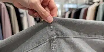 Hand performing 3-Point Seam Test on clothing seam