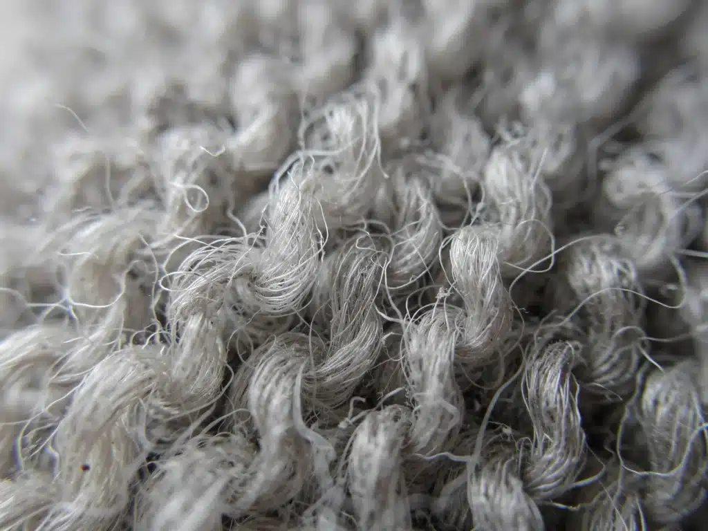 Macro view of crimped Merino wool fibers, illustrating natural elasticity and strength.