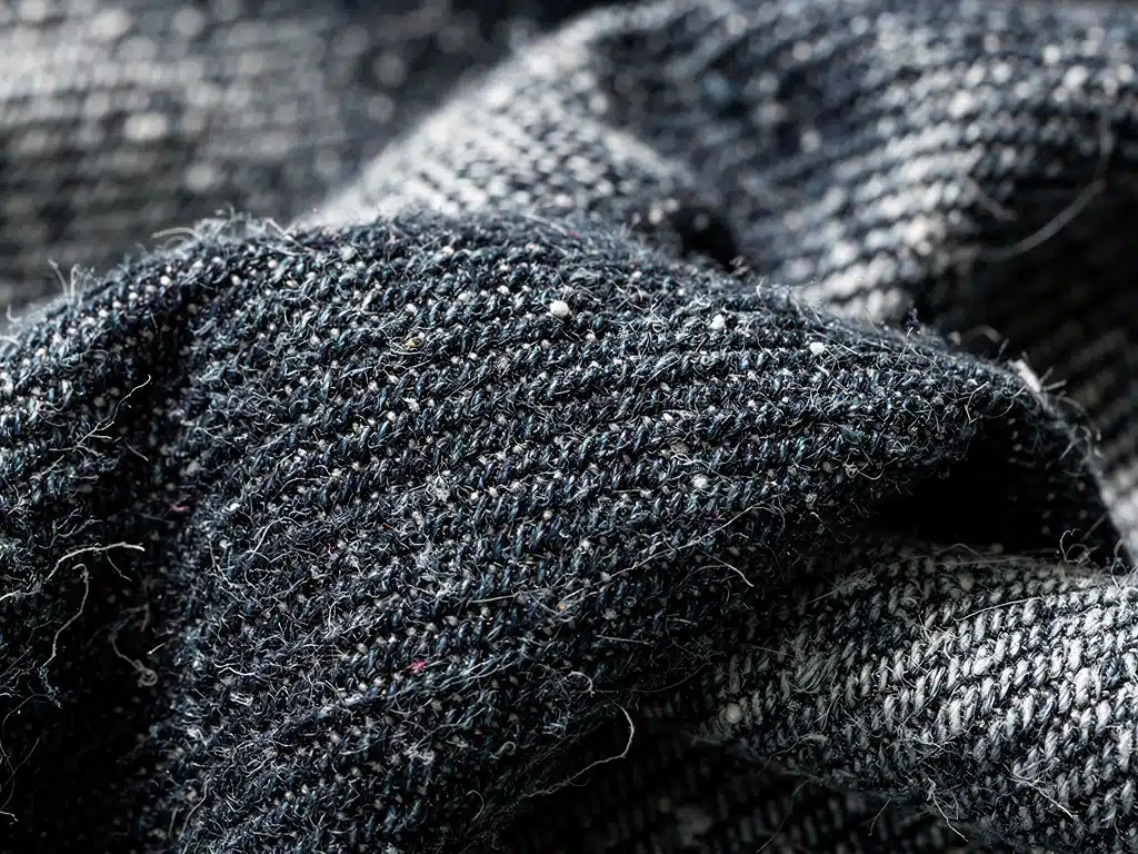Close-up of rigid 100% cotton denim weave, showing authentic texture.